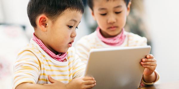 Two siblings watching tablet