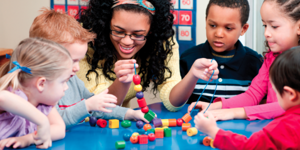 Teacher helping students build 