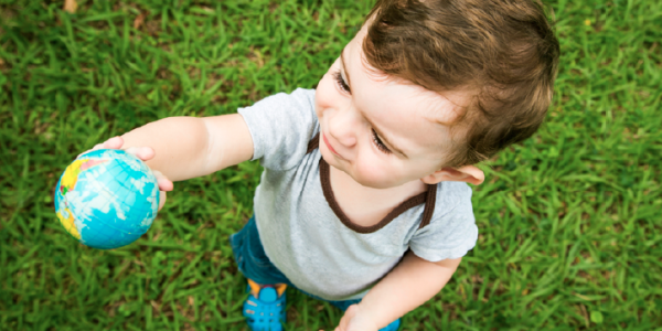 Toddler holding up a globe