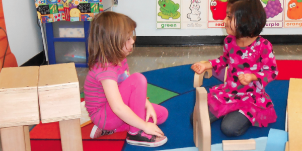 Two girls playing in block center