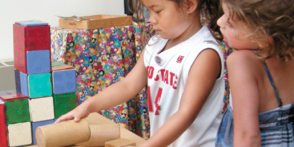 Two girls playing with blocks in classroom