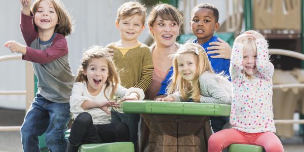 A teacher smiling outddors with her students