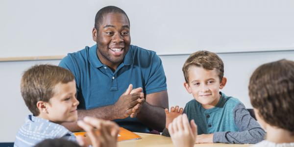 Teacher interacting with his three students.