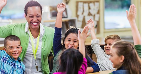 early educator playfully raising hand with children