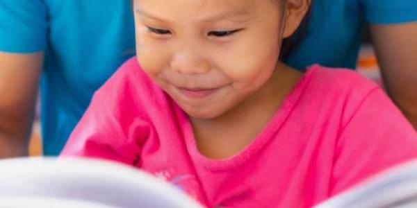 A young child reading a book.