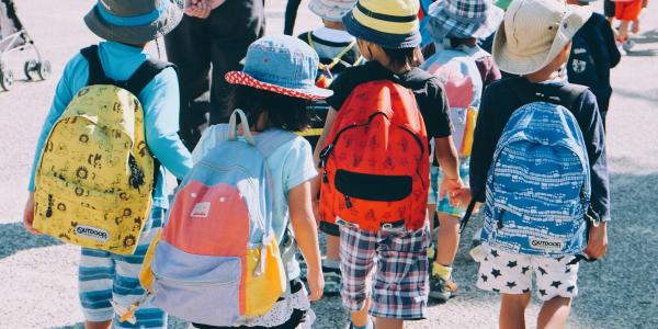 Children wearing backpacks head back to school.