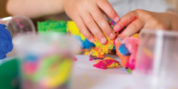 child's hands kneading playdough