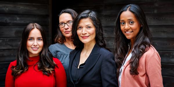 Four women standing and smiling