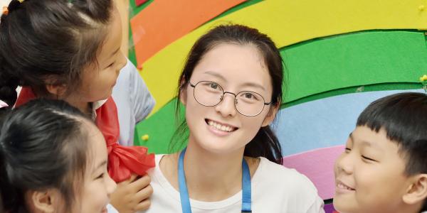 Teacher and three preschoolers in a classroom