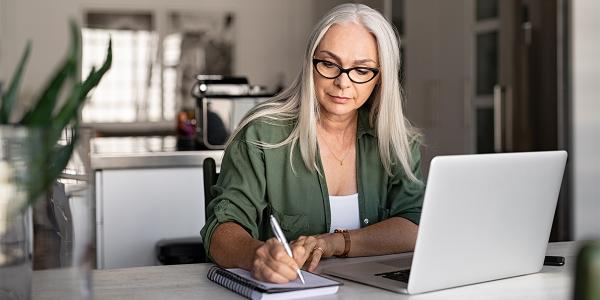 Woman at a laptop taking notes