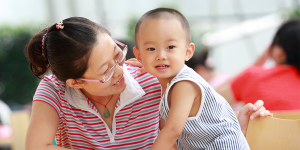 A parent supporting a young child.