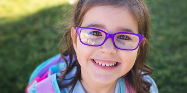 Young girl outside with backpack on.