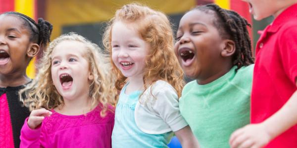 Group of five diverse children playing outdoors