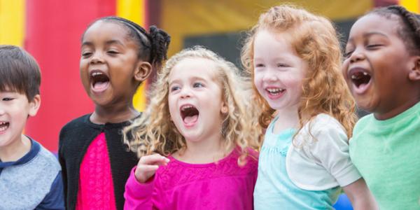 Group of children in the classroom laughing.