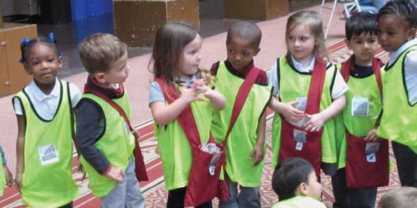 Children standing in a line and wearing safety vests