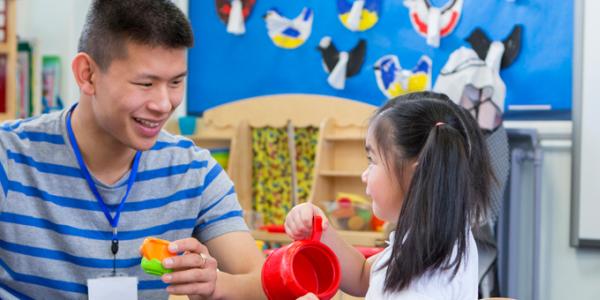 Teacher and young child interact in play.