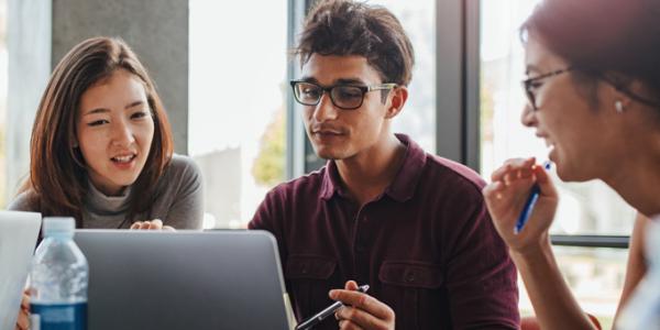 Four diverse professionals looking at computer screen