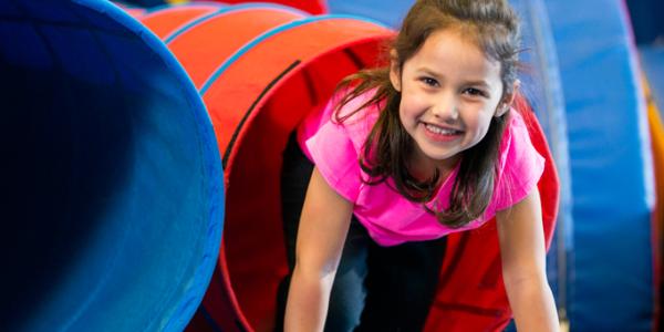 Little girl coming out of play tunnel