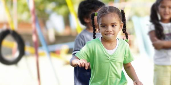 Young girl playing outside on the playground.