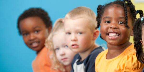Five diverse children smiling at camera