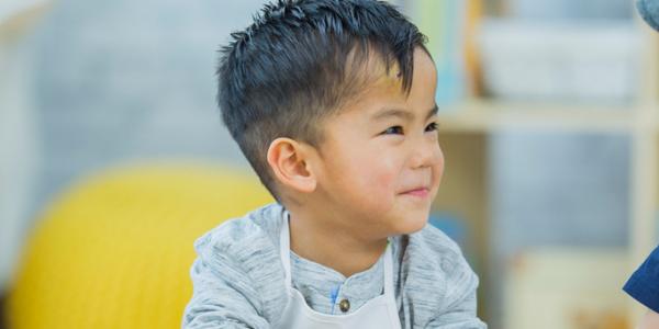 Two young boys at a table laughing