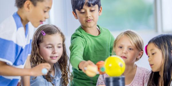 A small group of children conducts an experiment