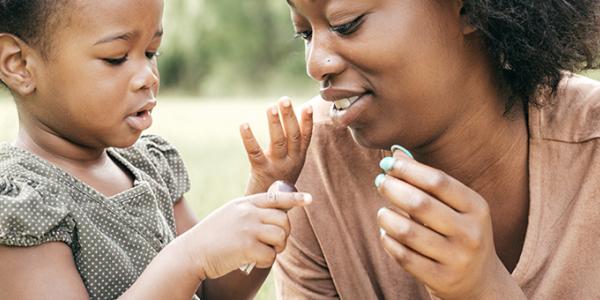 Young girl counting on her fingers with her mother.