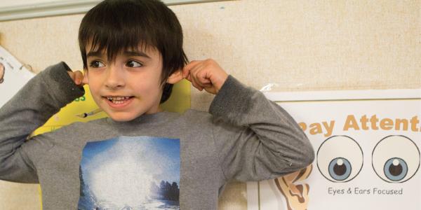 A young boy models "paying attention."