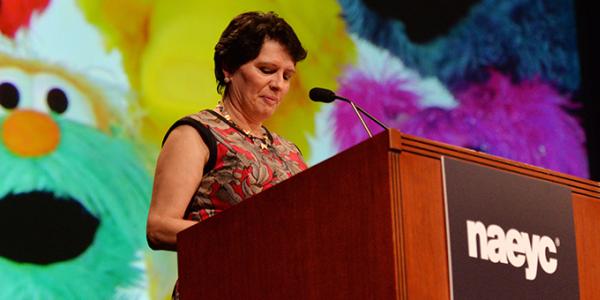 A presenter speaking from a podium at a conference