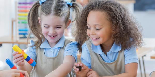 Two girls playing with loose parts as part of a STEM activity