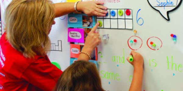 A teacher helps a child develop math concepts