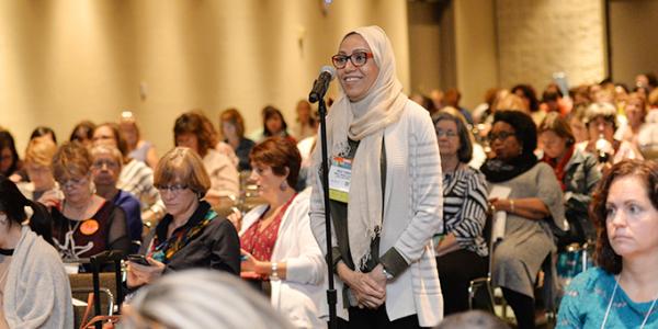 Woman in hijab speaking in a microphone during a conference event