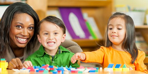 Teacher and children playing with blocks.