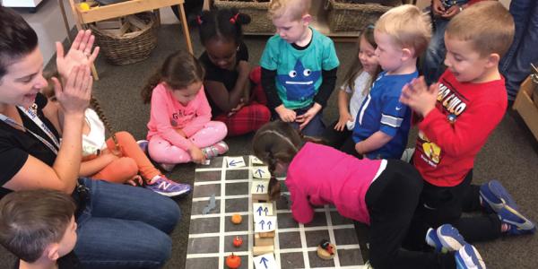 Teacher and preschoolers playing coding games