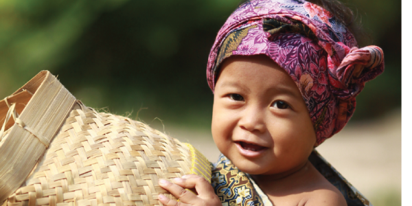 Young child in Indonesia with basket and colorful headscarf