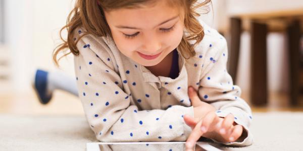 A young child draws on a tablet