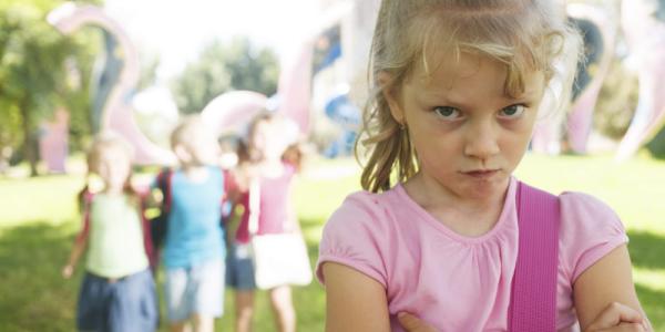 Unhappy girl with trio of girls behind her.