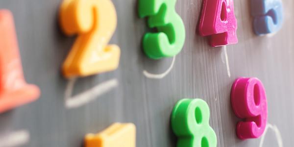 Colorful numbers hanging on a chalk board.