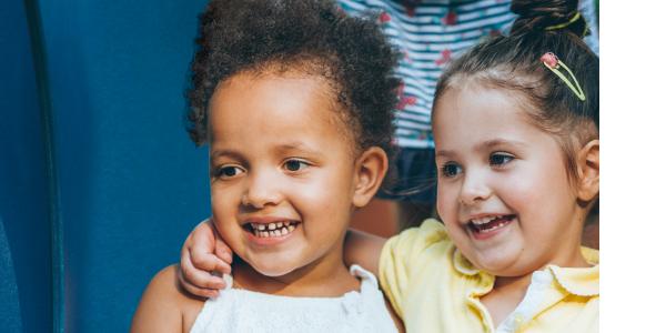 Two diverse young girls smiling