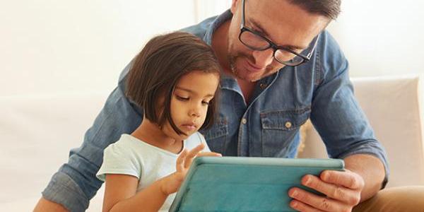 father and daughter looking at computer tablet