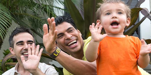 Two adults playing outside with a child.