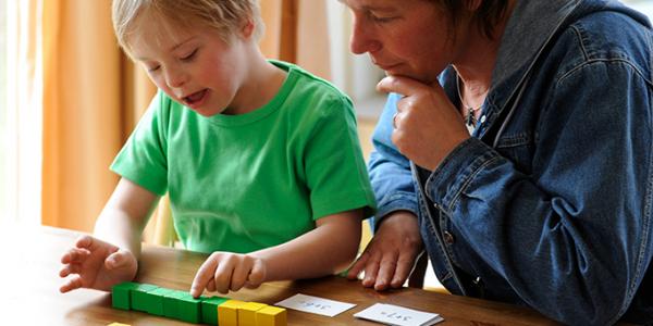 Mother and son reading cards and counting blocks