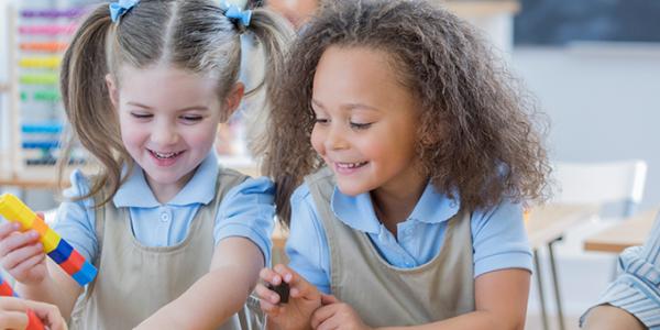 Preschool girls playing with plastic blocks