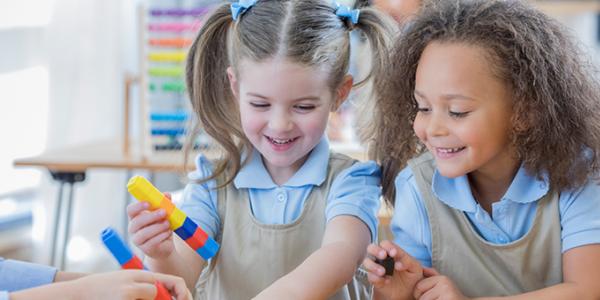 Children building with colored cubes.