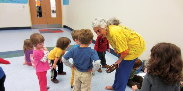 Teacher bending over and talking to students