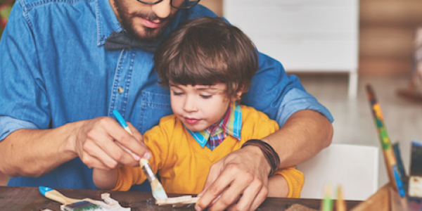 Father and son painting wooden materials