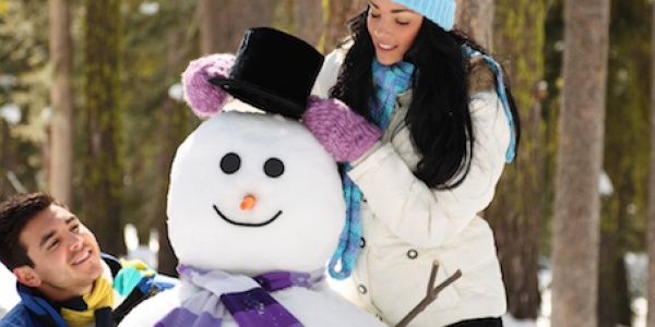 Two adults building a snowman