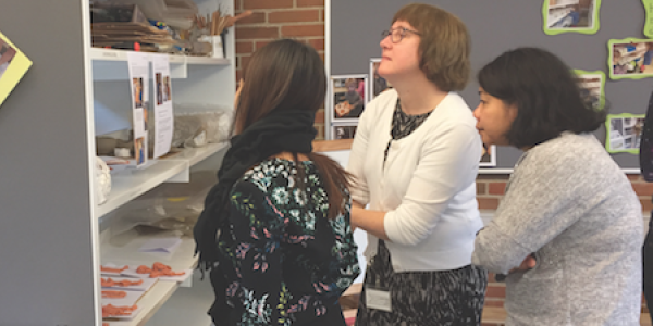 Three teachers looking at student artwork