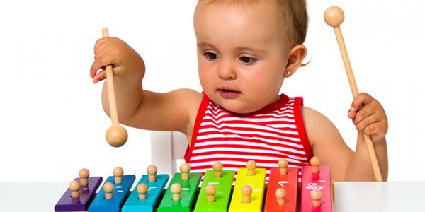A baby playing on a toy xylophone.