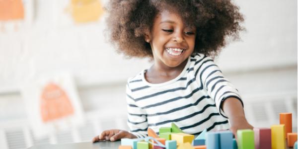 A happy child playing with blocks.